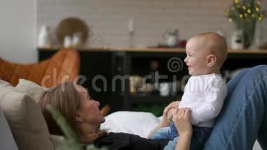 生命中最美好的时刻，一位充满爱心的年轻母亲在雪白的毯子上，在洁白的毯子上拥抱一个哺育的儿子
